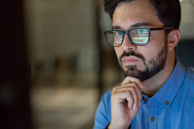 man pondering with computer reflections